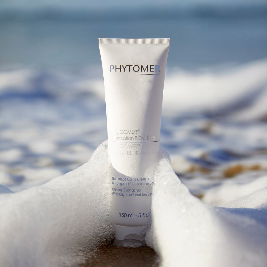 Phytomer Creamy Body Scrub with Oligomer and Two Sands on a beach with ocean in the background