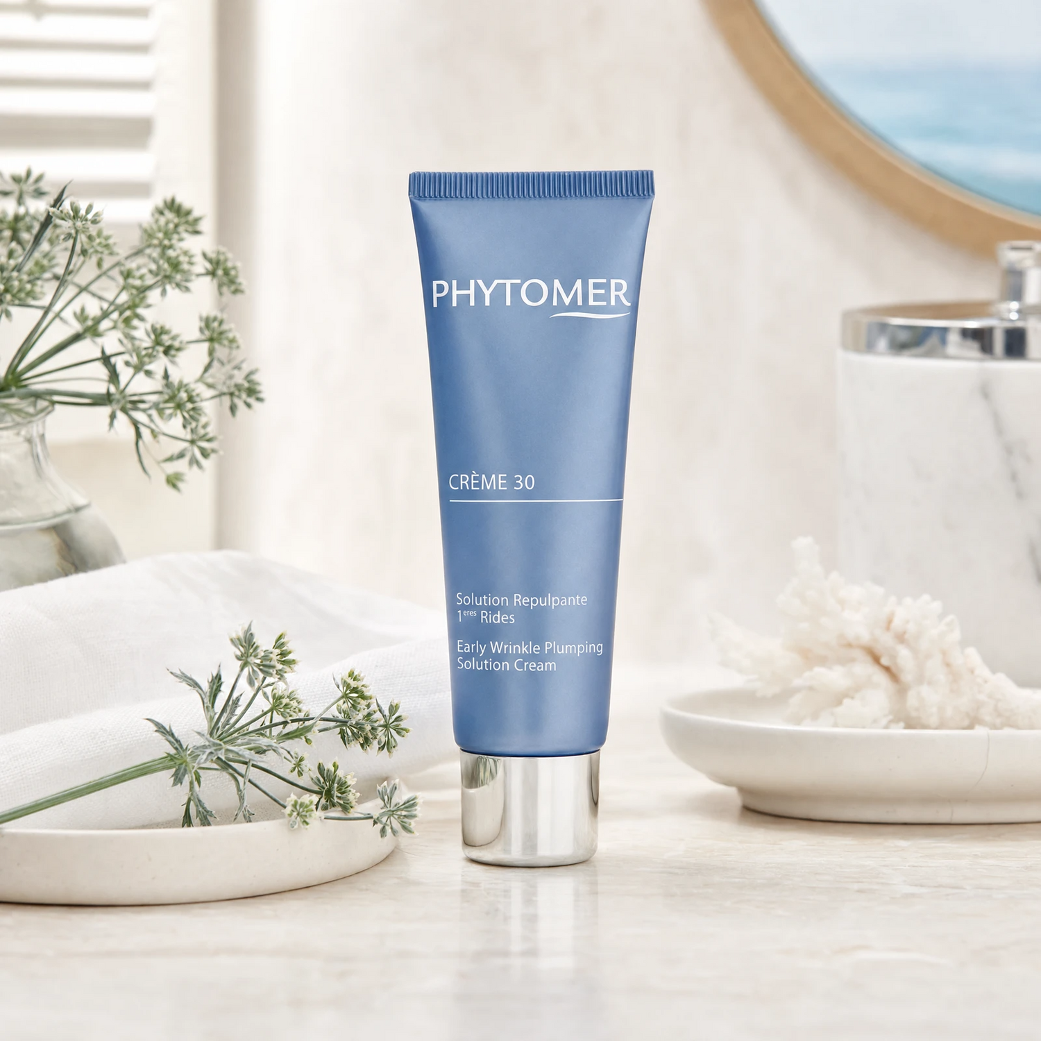 Phytomer Crème 30 Early Wrinkle Plumping Solution Cream 50ml on a marble bathroom vanity with sea fennel, glass vessel, white towels and ceramic tray, premium at-home skincare setting