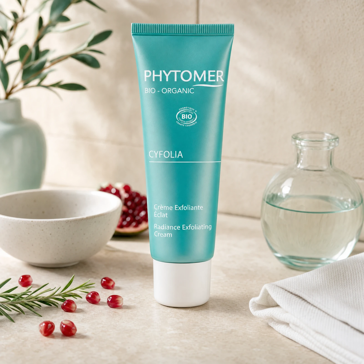 Phytomer Cyfolia Organic Radiance Exfoliating Cream 50ml on a stone bathroom vanity with pomegranate seeds, rosemary, glass vessel and white bowl, premium at-home organic skincare setting