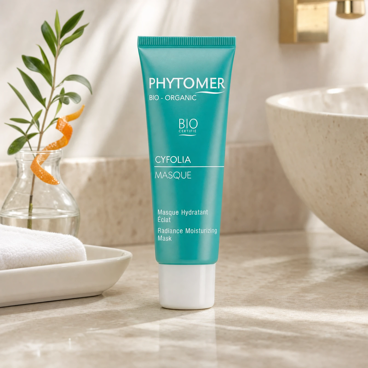 Phytomer Cyfolia Organic Radiance Moisturising Mask 50ml on a marble bathroom counter with orange peel curl in glass vase, white ceramic tray, white towels and gold tap, premium at-home organic skincare setting