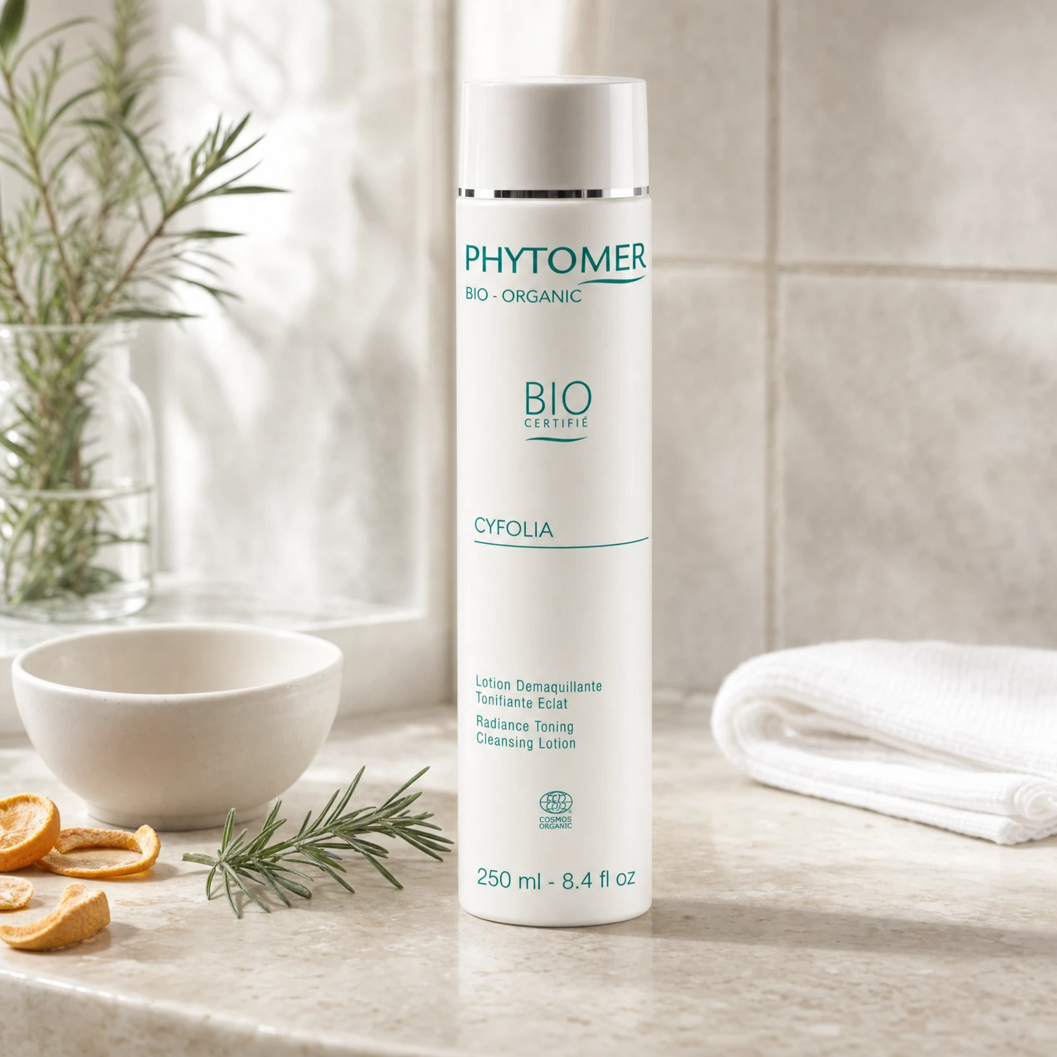 Phytomer Cyfolia Organic Radiance Toning Cleansing Lotion 250ml on a stone bathroom counter with dried citrus, rosemary in glass vessel and white bowl, premium at-home organic skincare setting