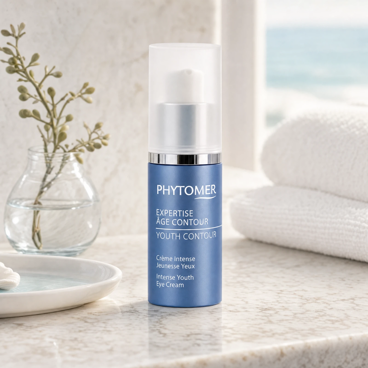 Phytomer Expertise Age Contour Intense Youth Eye Cream 15ml on a marble bathroom vanity with glass vessel with botanicals, white towels and ceramic dish, premium at-home skincare setting
