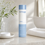 Phytomer Ogenage Toning Cleansing Emulsion 250ml on a marble bathroom vanity with botanical in glass vessel, cotton pads, white towels and glass of water, premium at-home skincare setting