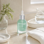 Phytomer Oligoforce Advanced Wrinkle and Dark Spot Correction Serum 30ml on a marble bathroom vanity with ceramic tray, glass vessel, sea botanical and white face cloth, premium at-home skincare setting