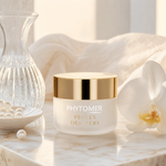 Phytomer Perles des Mers Longevity Cream 50ml on a polished marble surface with lustrous pearls, crystal vessel with water, white orchid and ivory linen, prestige editorial skincare setting