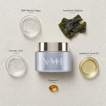 Phytomer Pionniere XMF Exfoliating Mask flatlay on limestone surface with XMF Marine Sugar, Laminaria Digitata, Glycolic Acid, Sunflower Seed Oil, and Vitamin E