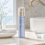 Phytomer Pionniere XMF Wrinkle and Dark Spot Supreme Serum 30ml on a marble bathroom vanity with coastal botanical in glass vessel, white ceramic dish and glass of water, premium at-home skincare setting