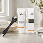 Vie Collection Dermo-Stimulating Massage Cream 50ml Limited Edition with facial roller applicator and retail box on a marble counter with olive branch in white vase, marble bowl with towels and soft window light, premium at-home skincare setting