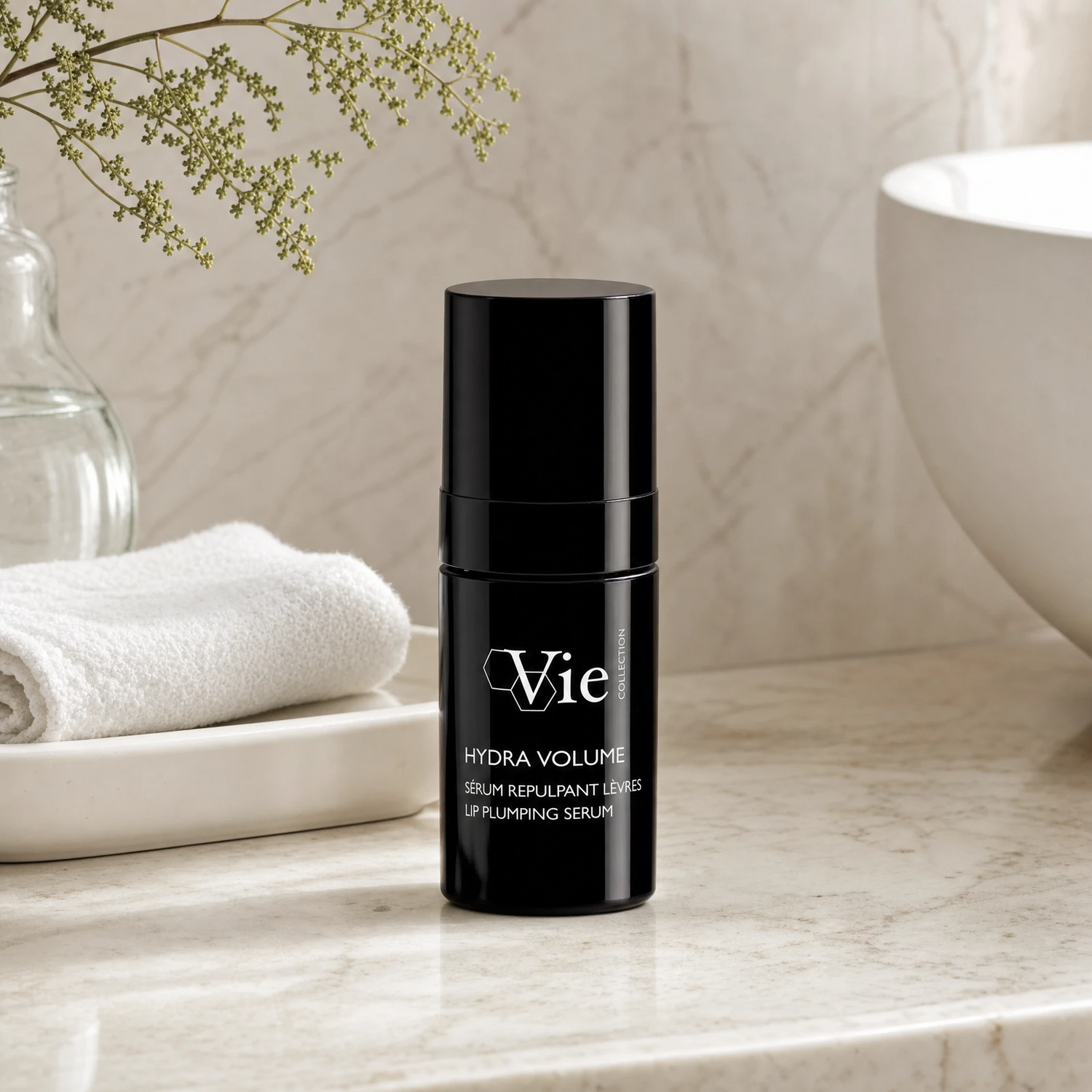 Vie Collection Hydra Volume Lip Plumping Serum 15ml on a marble bathroom counter with gypsophila in glass carafe, white ceramic tray, stacked white waffle towels and white basin in background, premium at-home skincare setting