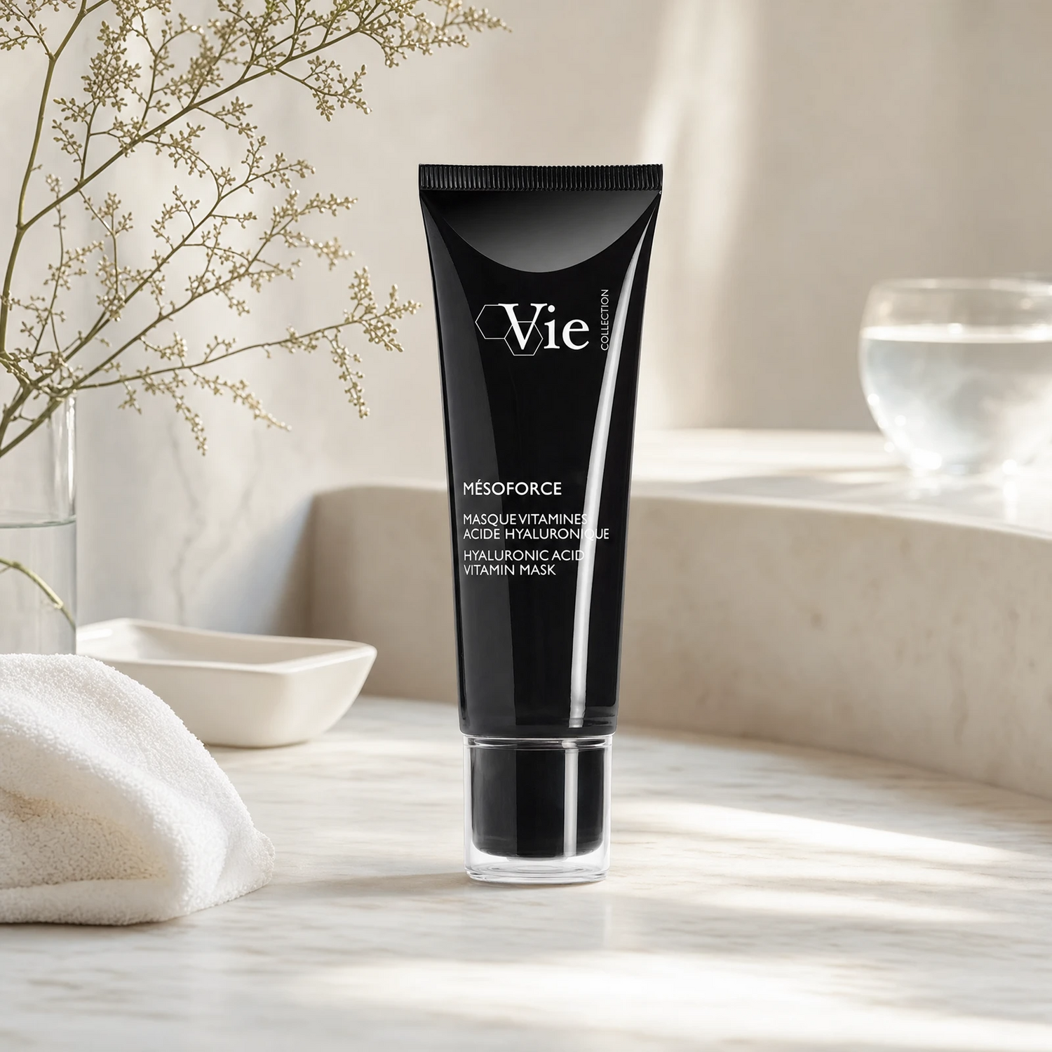 Vie Collection Mésoforce Hyaluronic Acid Vitamin Mask on a marble bathroom counter with gypsophila in glass carafe, white ceramic bowl tray, white waffle towel and glass of water, premium at-home skincare setting