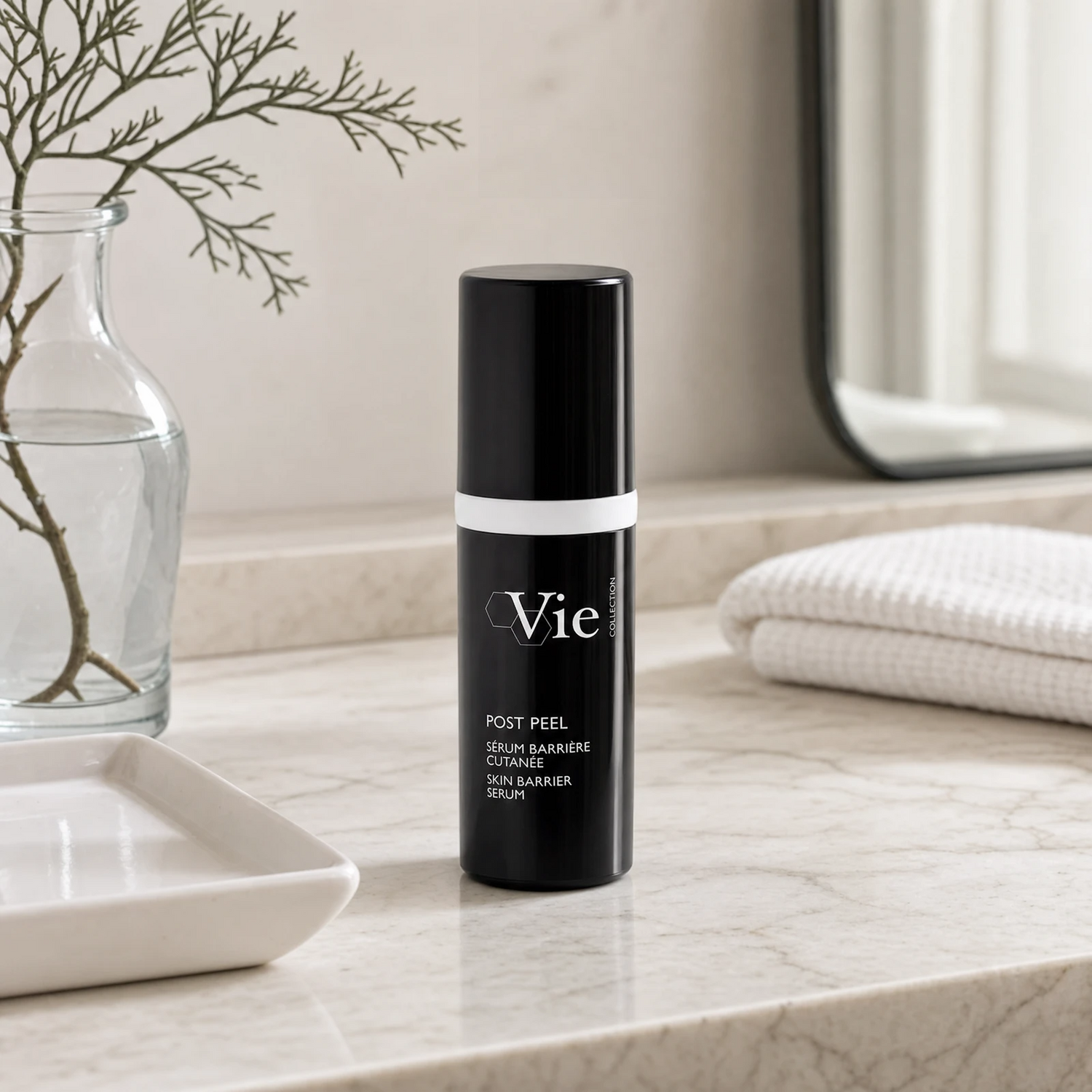 Vie Collection Post Peel Skin Barrier Serum 30ml on a marble bathroom counter with dried coral branch in glass carafe, white ceramic tray, stacked white waffle towels and round mirror, premium at-home skincare setting