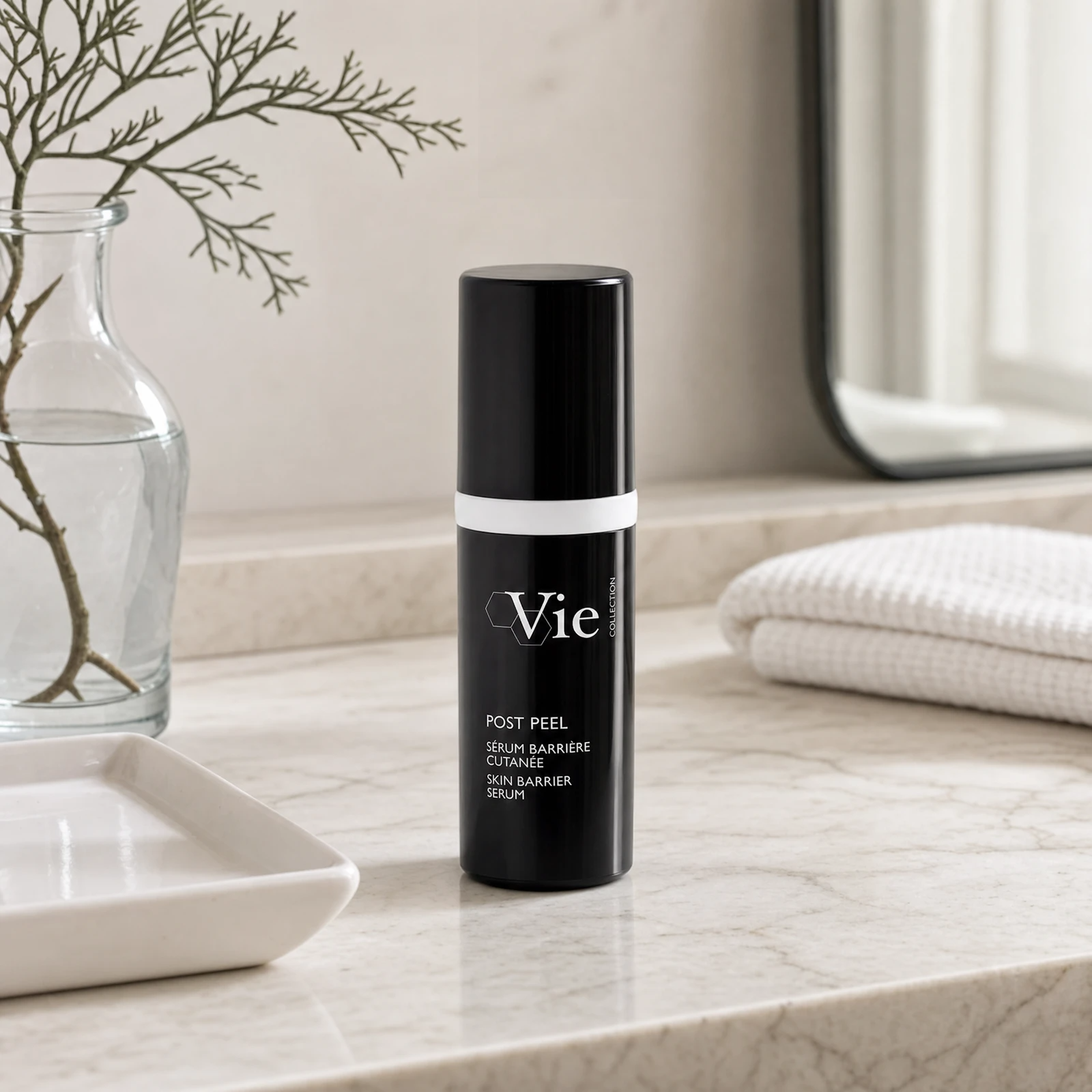 Vie Collection Post Peel Skin Barrier Serum 30ml on a marble bathroom counter with dried coral branch in glass carafe, white ceramic tray, stacked white waffle towels and round mirror, premium at-home skincare setting
