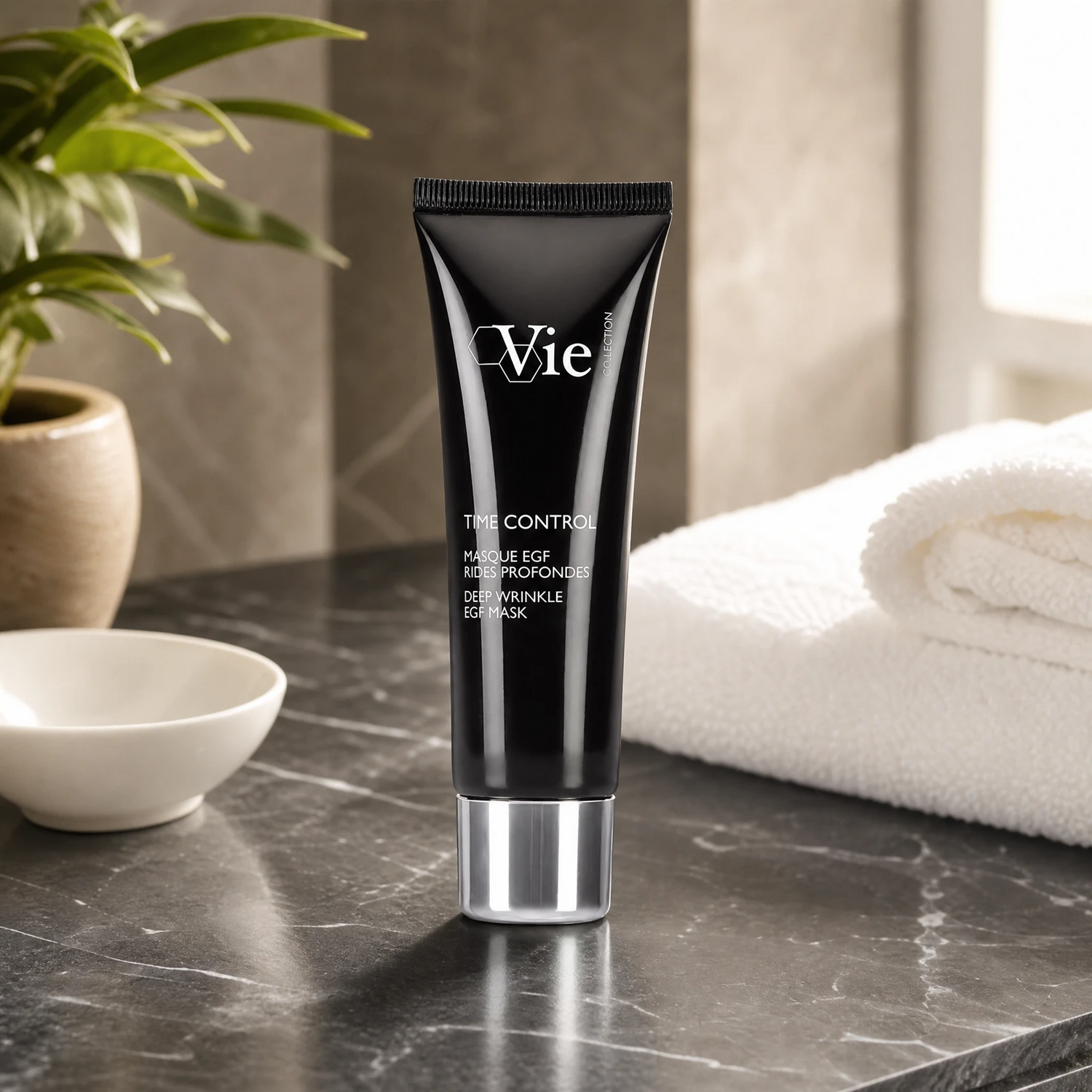 Vie Collection Time Control Deep Wrinkle EGF Mask 50ml premium matte-black tube with silver cap styled on a dark marble vanity with white towels and greenery for Beauty Collective consumer retail.