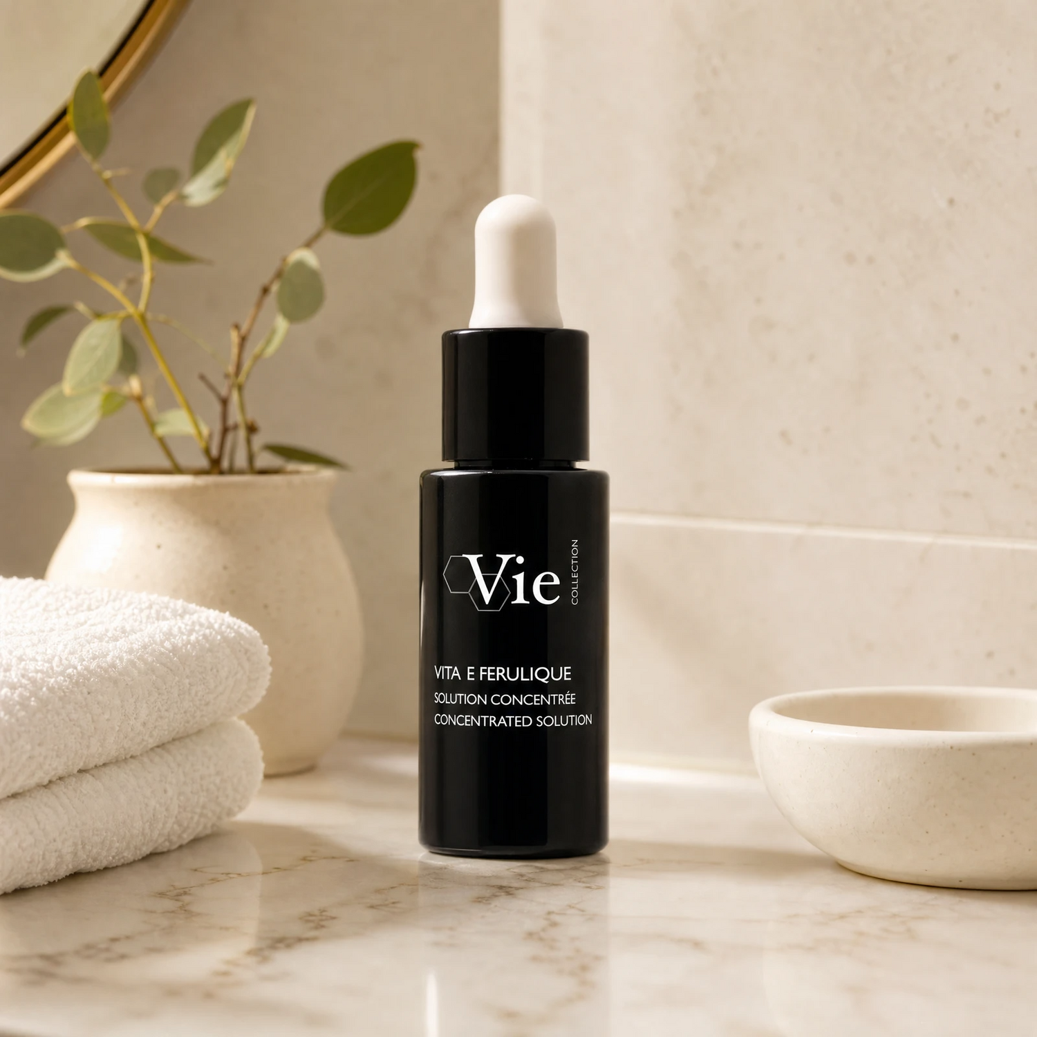 Vie Collection Vita E Ferulic Concentrated Solution 15ml premium matte-black dropper bottle styled on a marble vanity with white towels and greenery for Beauty Collective consumer retail.
